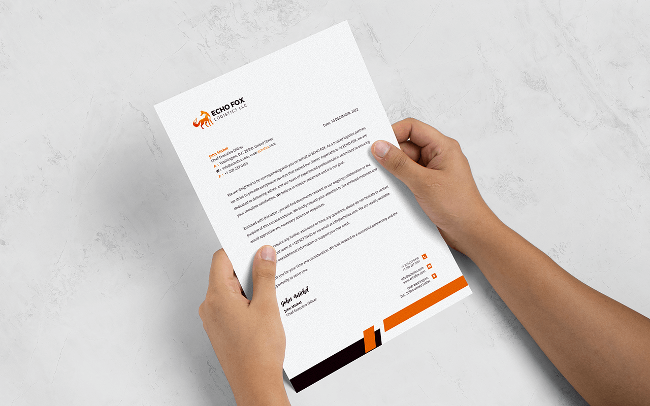 A person holding a letterhead and a business card