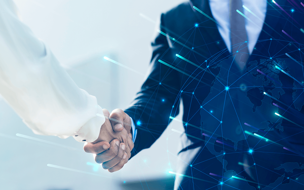 Two people shaking hands in front of a world map